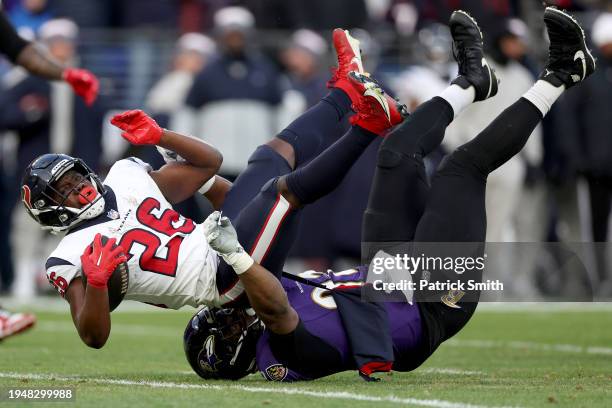 Justin Madubuike of the Baltimore Ravens tackles Devin Singletary of the Houston Texans during the first quarter in the AFC Divisional Playoff game...