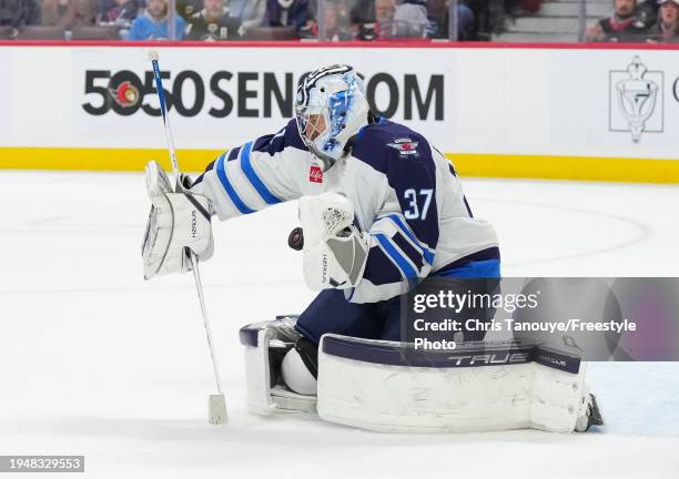 Connor Hellebuyck of the Winnipeg Jets makes a save in overtime against the Ottawa Senators at Canadian Tire Centre on January 20, 2024 in Ottawa,...