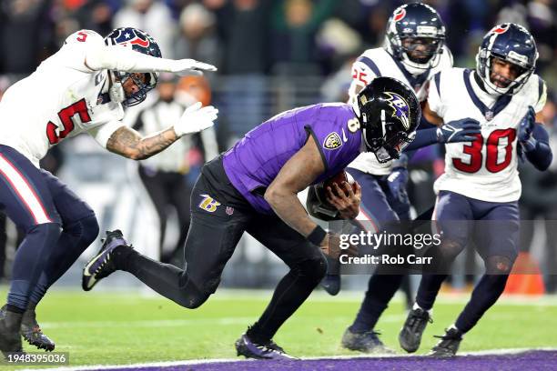 Lamar Jackson of the Baltimore Ravens scores a 15 yard touchdown against Jalen Pitre of the Houston Texans during the third quarter in the AFC...