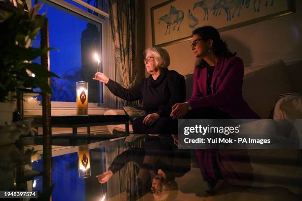 Holocaust survivor Joan Salter lights a memorial candle at her home in north London, accompanied by Olivia Marks-Woldman, Chief Executive Holocaust...