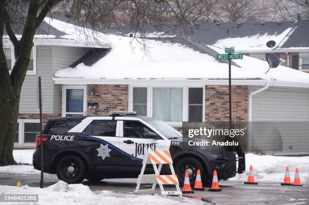 Police officers investigate at the scene where eight people were found shot to death in two homes in Joliet, United States on January 23, 2024....