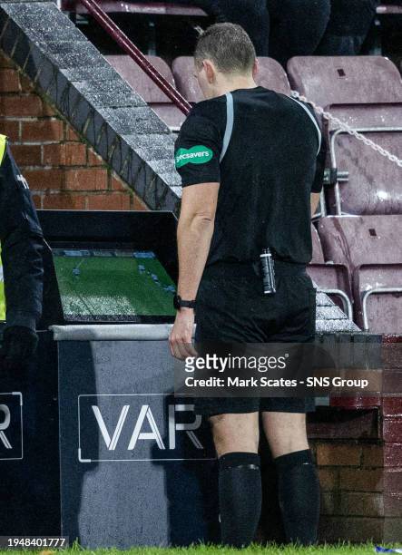 Referee Chris Graham checks VAR for grappling in the penalty area between Hearts' Lawrence Shankland and Dundee's Joe Shaughnessy which results in a...