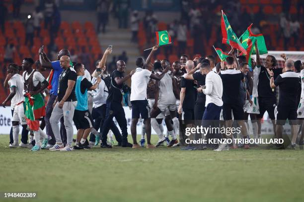 Mauritania's team and staff celebrate after they won the Africa Cup of Nations 2024 group D football match between Mauritania and Algeria at Stade de...
