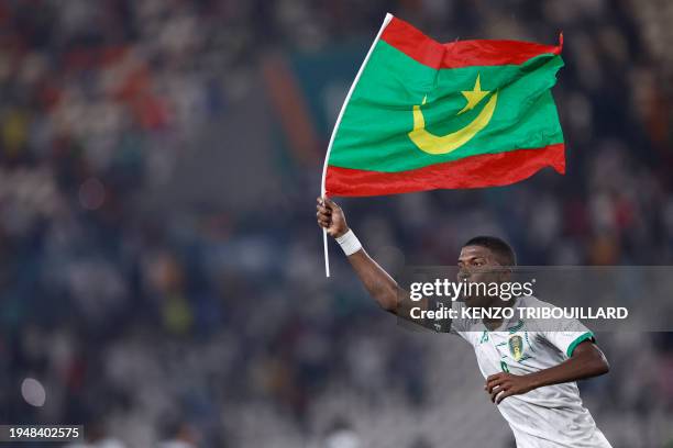 Mauritania's midfielder Bodda Mouhsine holds a Mauritania flag after his team won the Africa Cup of Nations 2024 group D football match between...