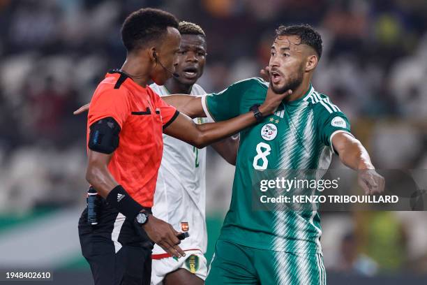Somalian referee Omar Abdulkadir Artan puts his hand on Algeria's forward Youcef Belaili's neck during the Africa Cup of Nations 2024 group D...
