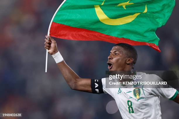 Mauritania's midfielder Bodda Mouhsine holds a Mauritania flag after his team won the Africa Cup of Nations 2024 group D football match between...