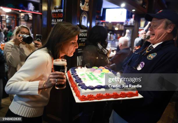 Republican presidential candidate former U.N. Ambassador Nikki Haley blows the candles out on a birthday cake presented to her by James Cromer as she...