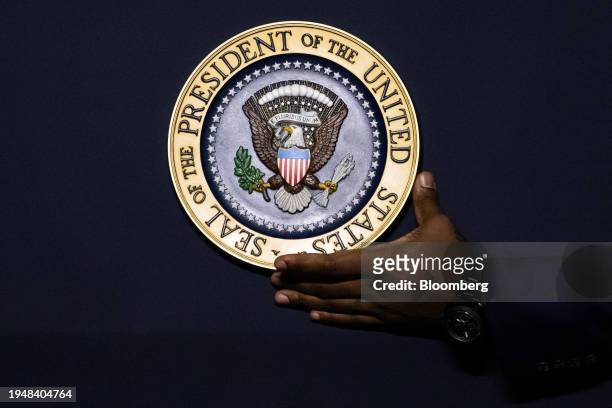Worker attaches the presidential seal to a podium prior to a reproductive freedom campaign rally with US President Joe Biden and Vice President...