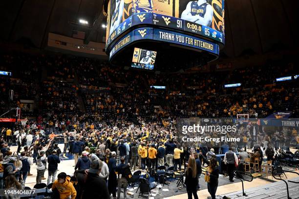 Fans storm the court after the West Virginia Mountaineers defeated the Kansas Jayhawks 91-85 at WVU Coliseum on January 20, 2024 in Morgantown, West...