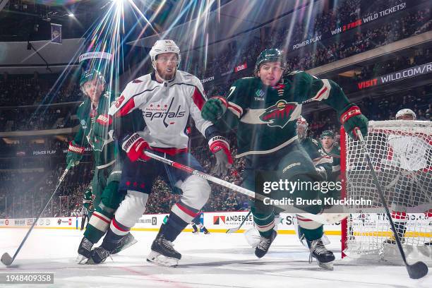 Brock Faber and Jonas Brodin of the Minnesota Wild defend Anthony Mantha of the Washington Capitals during the game at the Xcel Energy Center on...