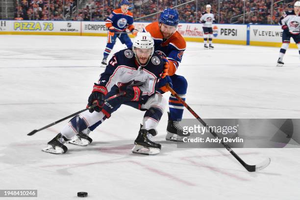 Justin Danforth of the Columbus Blue Jackets and Brett Kulak of the Edmonton Oilers battle for the puck during the game at Rogers Place on January 23...