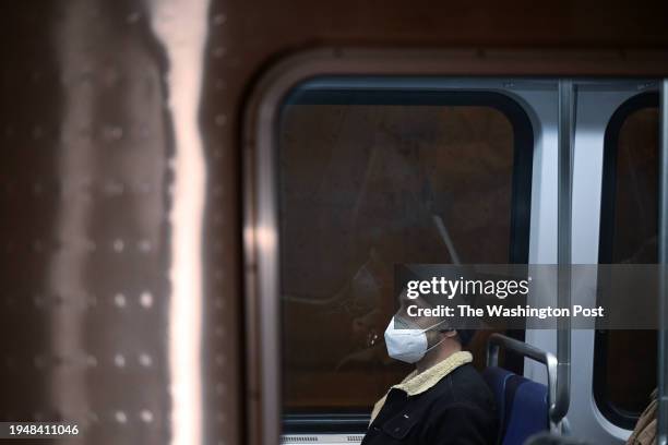 Passenger wears a mask while riding a train passing through the Metro Center station on Thursday January 04, 2024 in Washington, DC. There is...