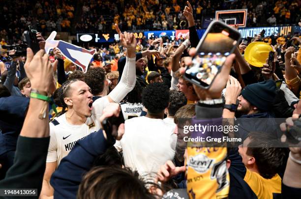 Patrick Suemnick of the West Virginia Mountaineers celebrates with fans after their 91-85 victory against the Kansas Jayhawks at WVU Coliseum on...