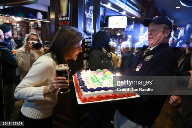 Republican presidential candidate former U.N. Ambassador Nikki Haley blows the candles out on a birthday cake presented to her by James Cromer as she...