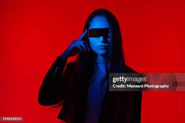 futuristic modern woman with smart glasses and red glowing background - glamour photos et images de collection