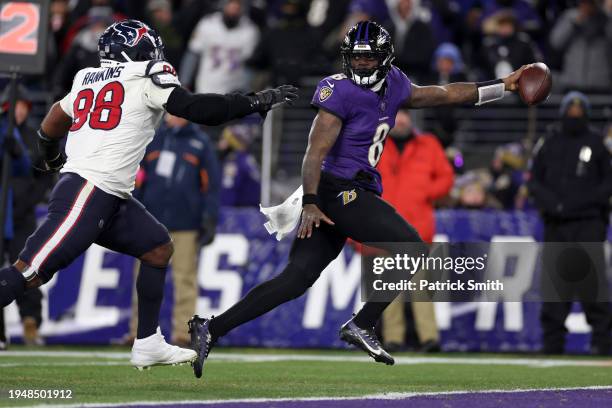 Lamar Jackson of the Baltimore Ravens scores an 8 yard touchdown against Sheldon Rankins of the Houston Texans during the fourth quarter in the AFC...