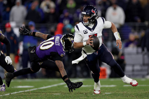 Stroud of the Houston Texans scrambles against Arthur Maulet of the Baltimore Ravens during the fourth quarter in the AFC Divisional Playoff game at...