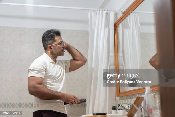 man combing hair in bathroom - pompadour stock pictures, royalty-free photos & images