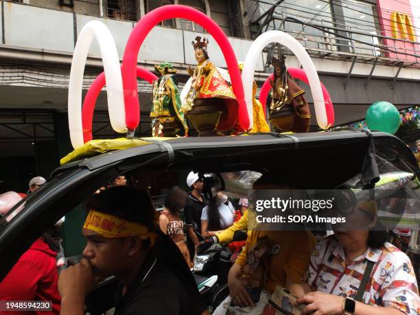 Images of Santo Niño are displayed atop a tricycle adorned with colorful balloons during the parade. The Feast of Santo Niño, honoring the Holy Child...