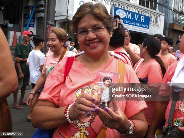 Devotee shows her miniature of Santo Niño during the parade. The Feast of Santo Niño, honoring the Holy Child Jesus, is observed every third Sunday...