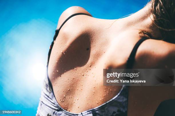 beautiful woman's back exposed to the sun - luce ultravioletta foto e immagini stock