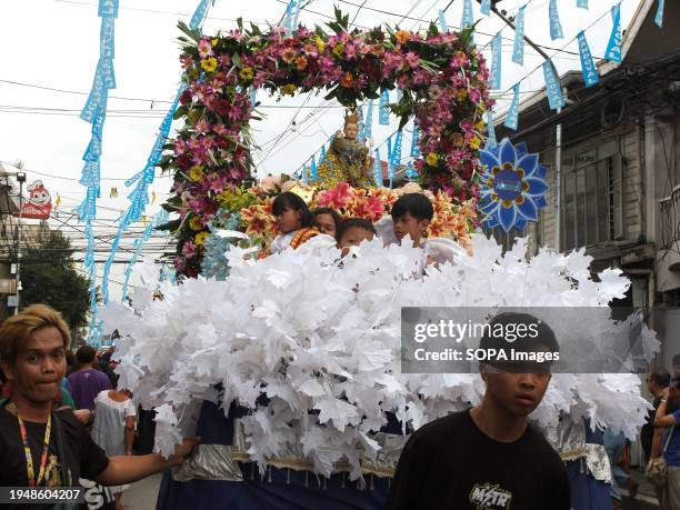 Children dressed as Santo Niño and angel costumes ride on a float carrying the image of Santo Niño during the parade. The Feast of Santo Niño,...