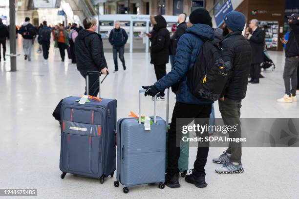 Commuters wait for delayed trains at Waterloo Station in London. Flights and trains have been cancelled, and "danger to life" warnings remain in...