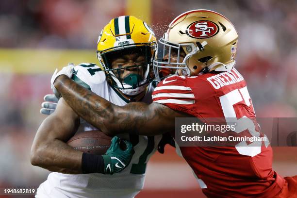 Dre Greenlaw of the San Francisco 49ers tackles Emanuel Wilson of the Green Bay Packers during the first half in the NFC Divisional Playoffs at...