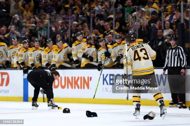 Danton Heinen of the Boston Bruins skates through hats thrown on the ice after he scored a hat trick goal against the Montreal Canadiens during the...