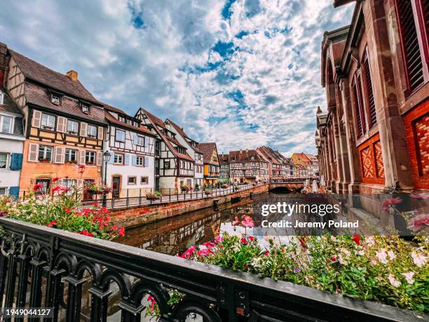 wide angle view of vibrant-colored alsatian-style french homes and businesses on the canal in colmar - colmar stockfoto's en -beelden