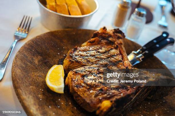 close-up florentine t-bone steak and lemon wedge - costeleta comida imagens e fotografias de stock