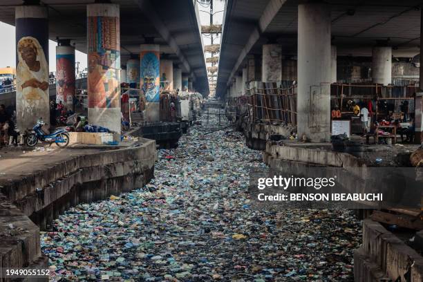 General view of a clogged up canal filled with styrofoam and single use plastic at Obalende in Lagos on January 23, 2024.