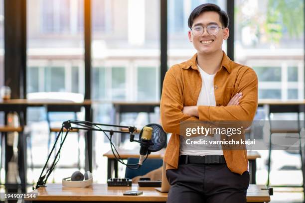 young man wearing headphones recording a podcast in the studio - business woman schild stockfoto's en -beelden