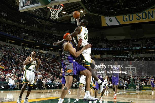 Reggie Evans of the Seattle Sonics goes to the basket against Scott Williams of the Phoenix Suns during the game at Key Arena on April 16, 2003 in...