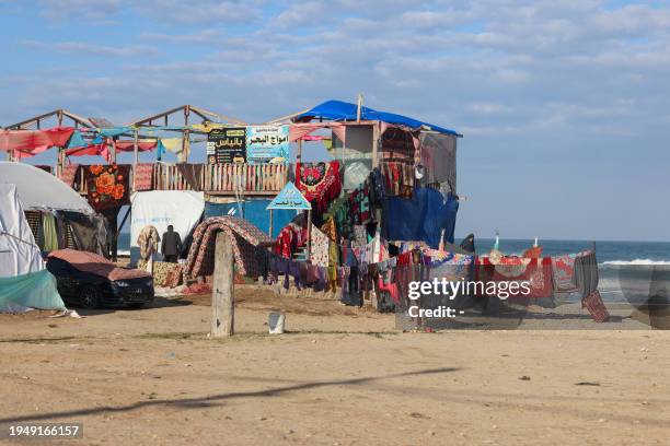 Bedding and clothes hang to dry outside of a beach coffee shop where people have taken shelter near a tent camp for displaced Palestinians in Rafah...
