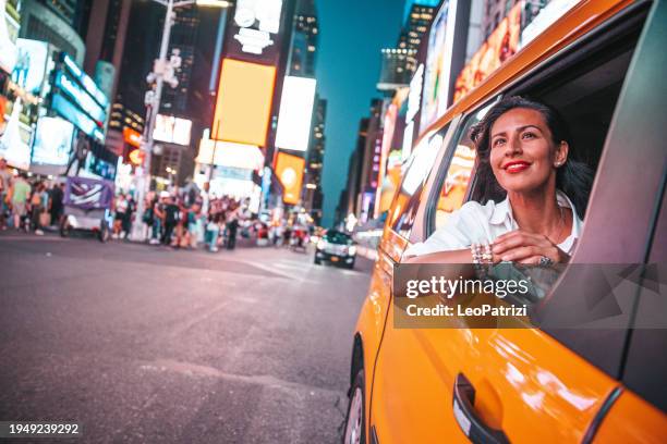 viaje en taxi en times square, nueva york - turista fotografías e imágenes de stock