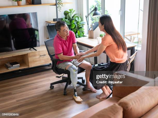 woman encourages and supports man with artificial limb - ibnjaafar stock pictures, royalty-free photos & images