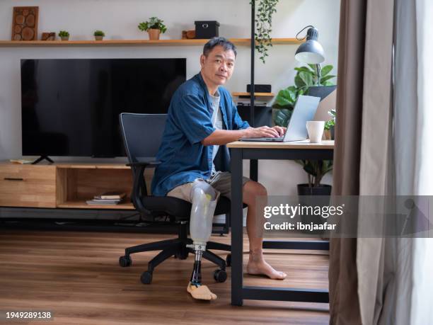 amputee man working online - ibnjaafar stock pictures, royalty-free photos & images