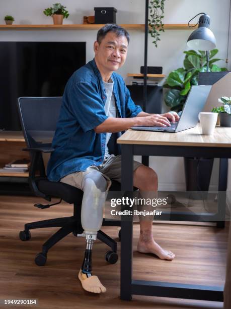 man with artificial limb browsing social media content online - ibnjaafar stock pictures, royalty-free photos & images