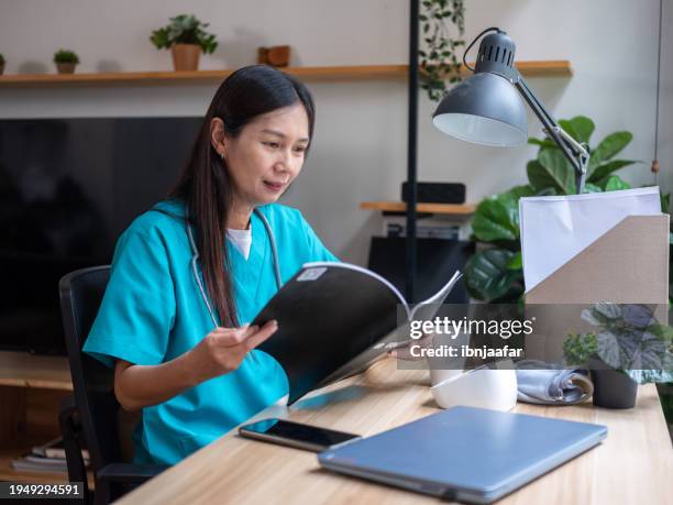 hospital folder, nurse looking medical record - ibnjaafar stock pictures, royalty-free photos & images