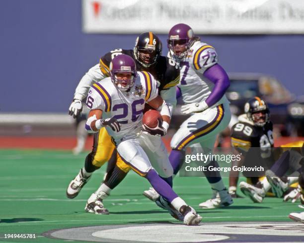 Running back Robert Smith of the Minnesota Vikings runs with the football as he is pursued by defensive lineman Brentson Buckner of the Pittsburgh...