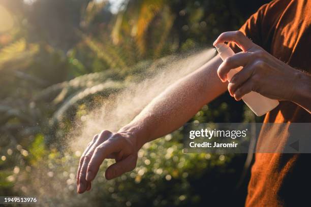 man while applying insect repellent - mosquito fotografías e imágenes de stock