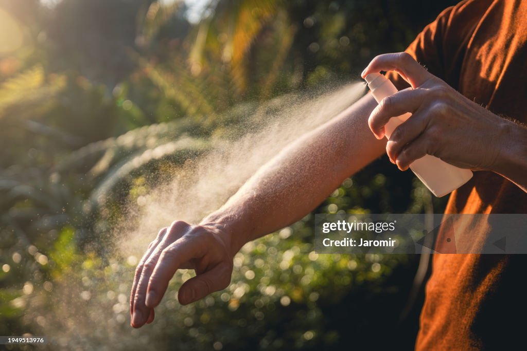 Man while applying insect repellent