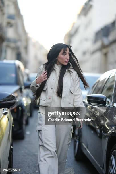 Clemence Mouline, Social Media Manager at Vogue France, wears a white jacket, a white ribbed wool pullover, white flared wide-leg cargo pants,...