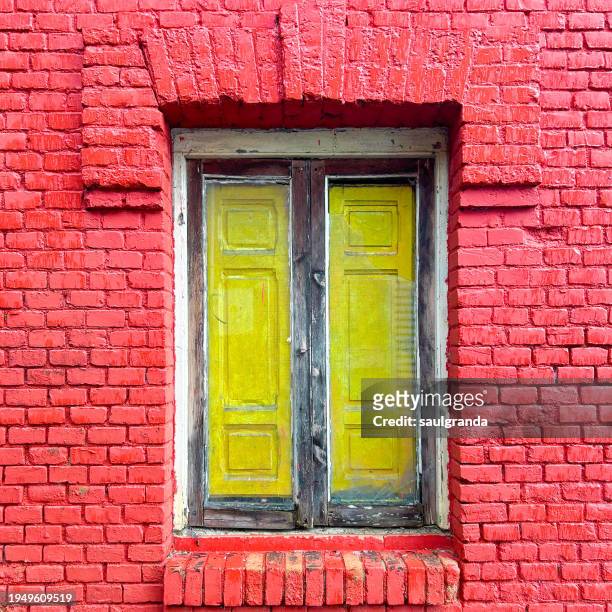 old wooden window on red brick facade - abandonado stockfoto's en -beelden