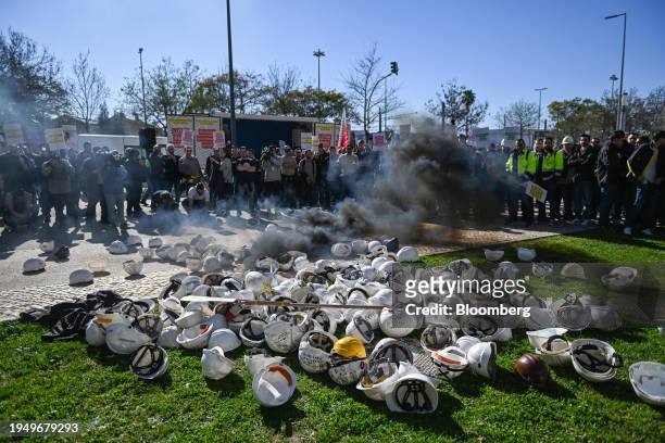 Energy sector workers let off smoke flares and throw away their safety helmets during a protest over pay outside the Energias de Portugal SA...
