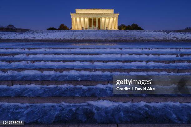 Ice and snow cover the steps leading to the Lincoln Memorial before daybreak on January 21, 2024 in Washington, DC. Freezing temperatures are...