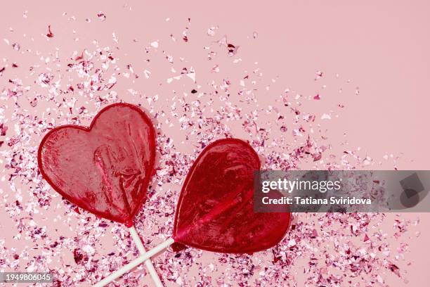 bright confetti and two lollipop hearts on pink background - lollipop stock pictures, royalty-free photos & images