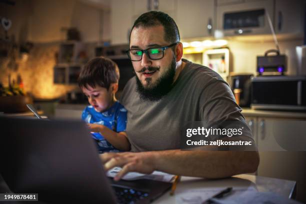 young dad using laptop checking bills and frustrated with financial problems - cost of living stock pictures, royalty-free photos & images