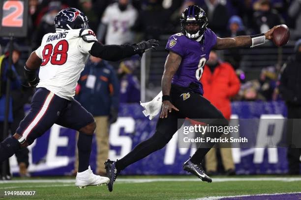 Quarterback Lamar Jackson of the Baltimore Ravens rushes for an 8-yard touchdown against Sheldon Rankins of the Houston Texans during the fourth...